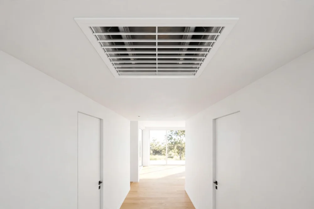 Clean white ceiling air vent register in hallway